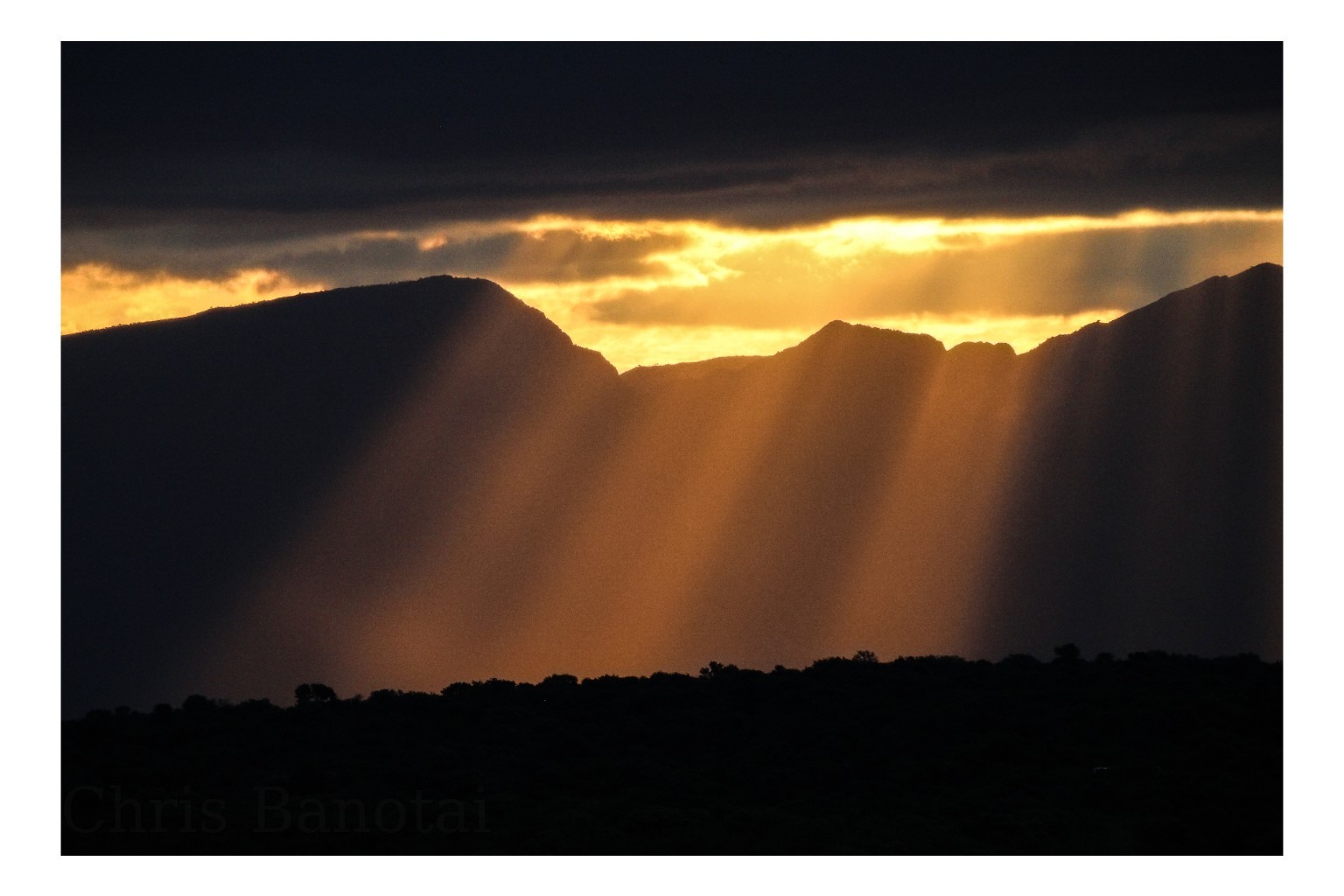 Sunbeams breaking through storm clouds over the Drakensberg Mountains, South Africa